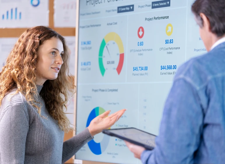 Woman presenting data on a digital screen.