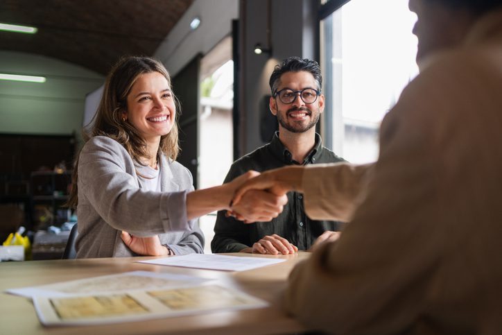 People shaking hands in a meeting.