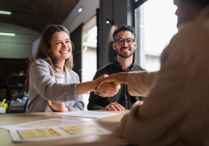 People shaking hands in a meeting.